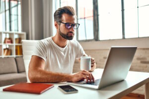 businessman-glasses-with-mug-coffee-works-laptop-freelance-work-from-home (1) - Computer Center Jeśli szukasz nowego laptopa do pracy lub nauki, warto zwrócić uwagę na nowy model Lenovo ThinkPad L14 Gen 3